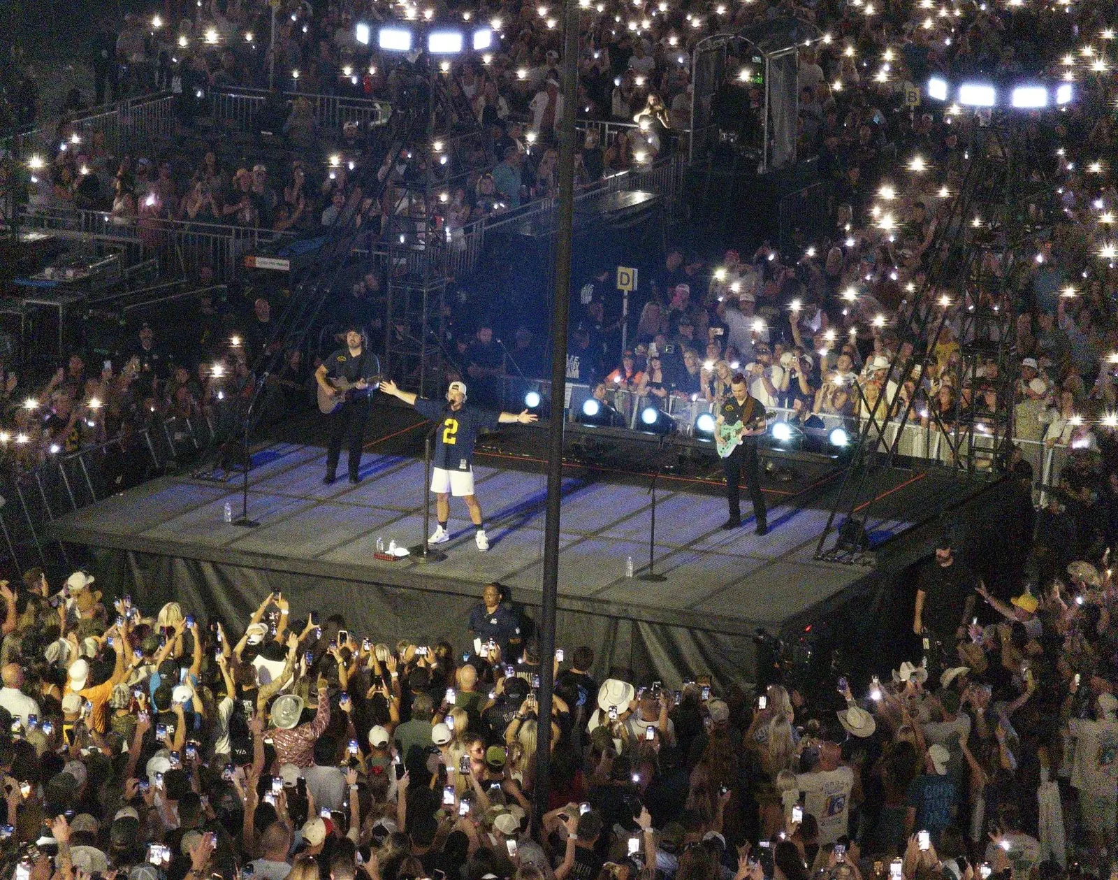 Morgan Wallen auf der B-Stage im Michigan Stadium Ann Arbor, dahinter tausende Handylichter, Still The Problem Tour 2026